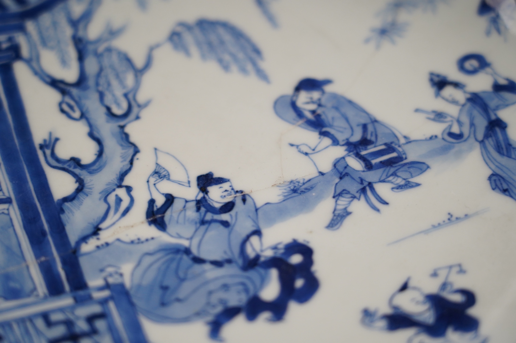 A Chinese blue and white dish, Kangxi period, broken and messily reglued